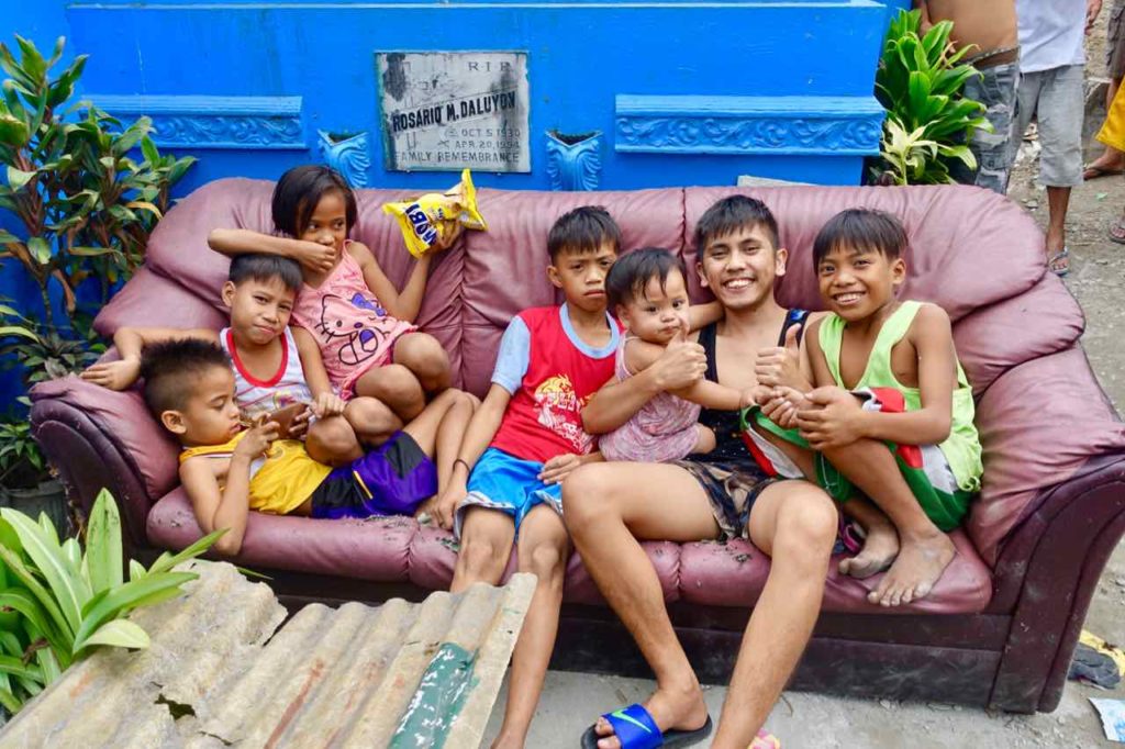 Nordfriedhof von Manila: Kinder posieren auf Couch für das Foto