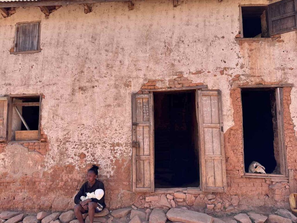 Sitzende Frau vor rotem Haus in Ambositra © PetersTravel Peter Pohle