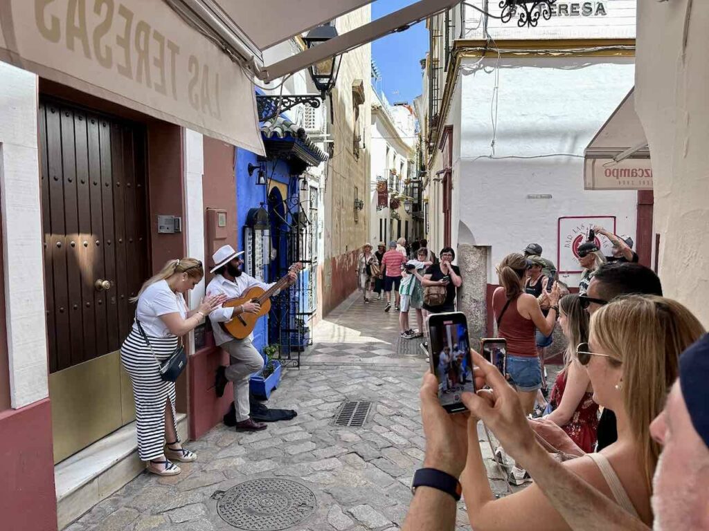 Sevilla, Gasse mit Straßenmusiker im Barrio Santa Cruz, Andalusien © PetersTravel Peter Pohle